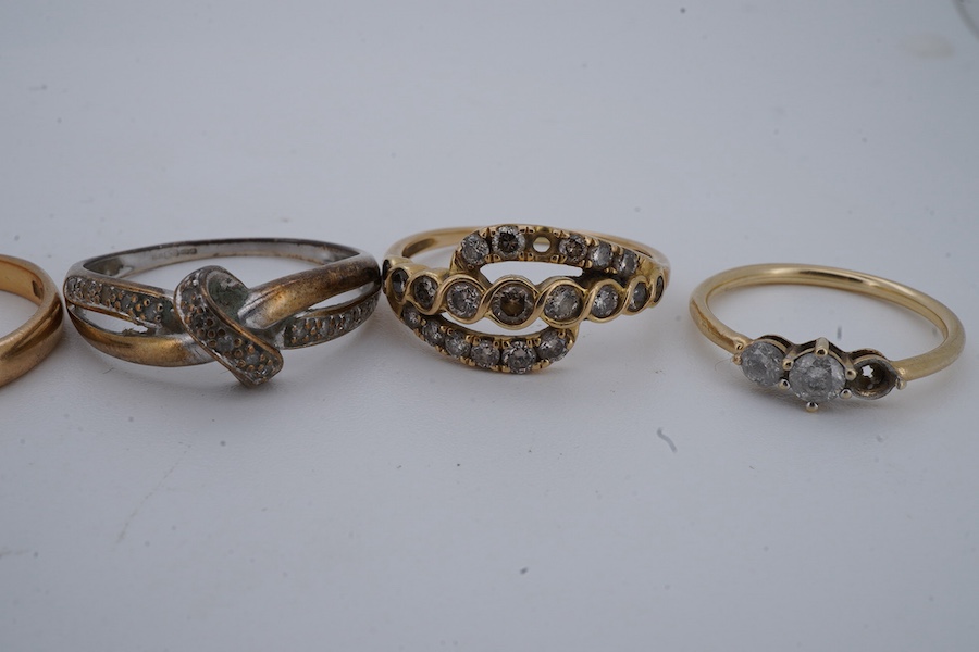 Six rings, comprising: a half eternity ring channel-set with tapered baguette diamonds, mounted in 18ct gold, size P1/2, British hallmarks, gross weight approximately 3 grams; one of half-hoop design, set with brilliant-